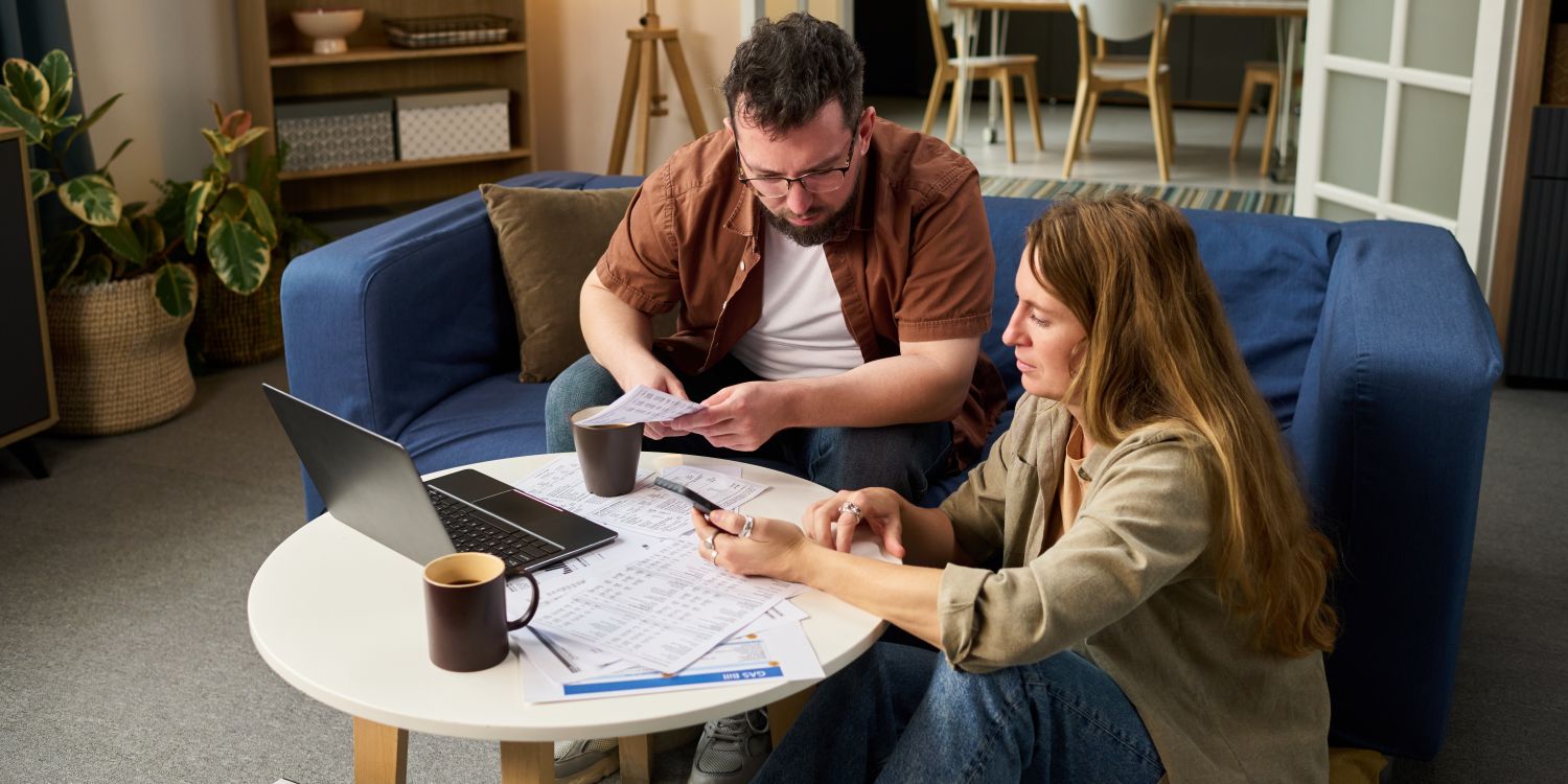 Mann und Frau am Tisch schauen auf Papiere