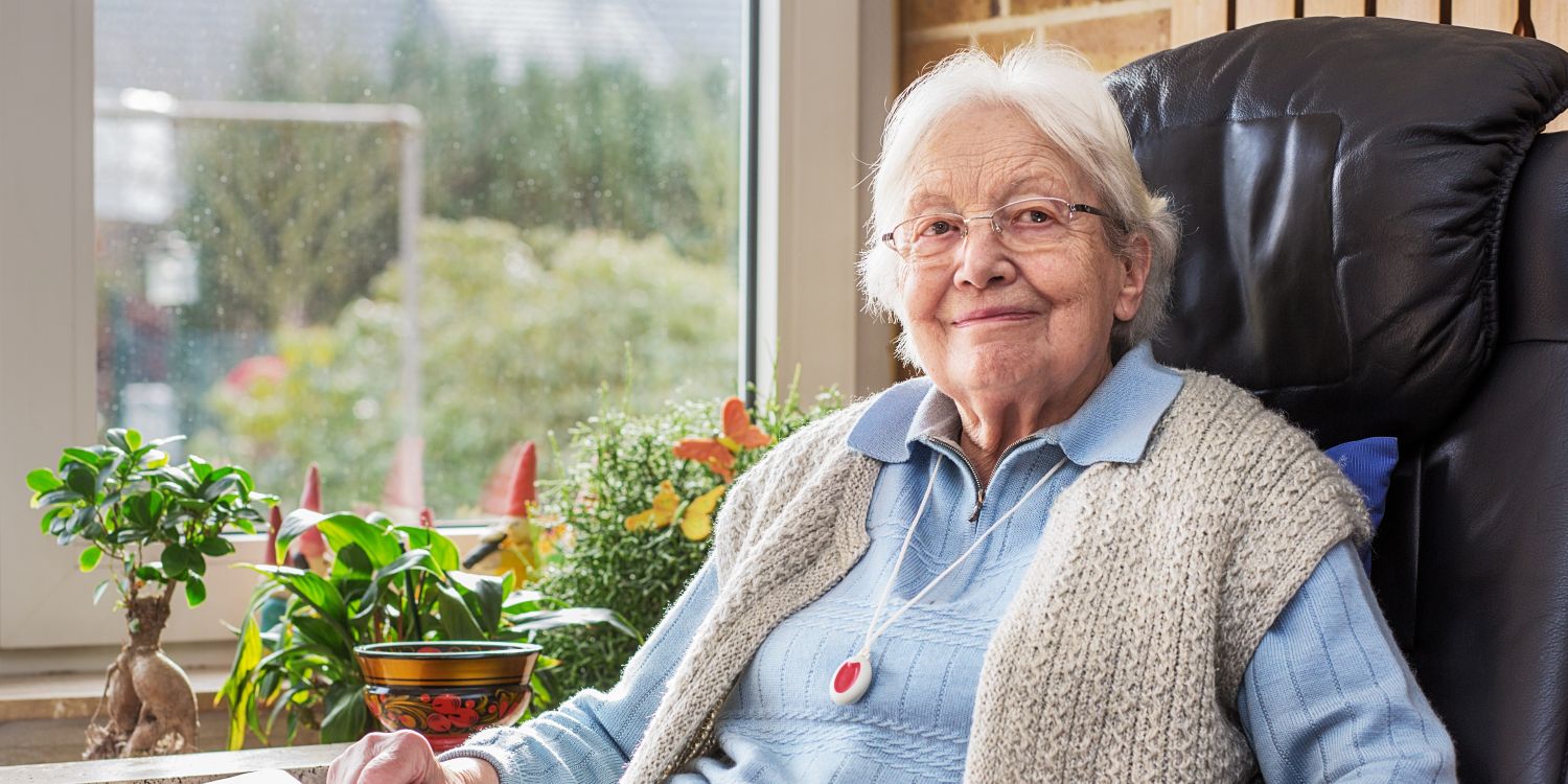 Dame sitzt lächelnd in einem Sessel