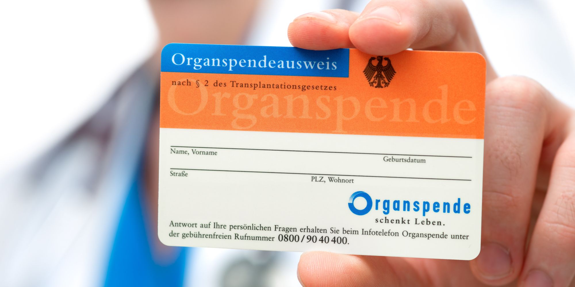 Person zeigt Organspendeausweis