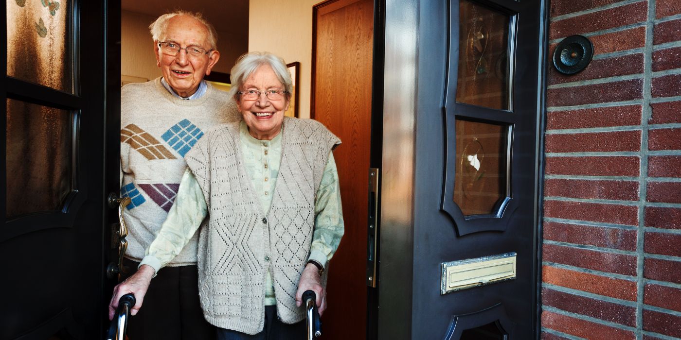 Älteres Ehepaar steht in der Haustür